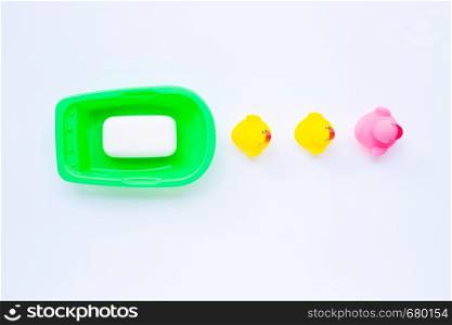 Pink and yellow duck toys with soap on white background. Kids bath concept.