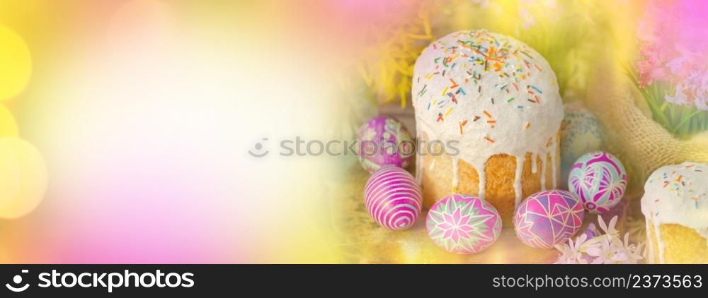 Pink and yellow Easter banner. Easter banner with Easter eggs and Easter cake. Empty place for text.. Easter bokeh banner. Easter morning at table with Easter eggs and Easter cakes.