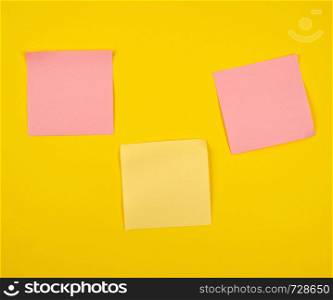 pink and yellow paper stickers pasted on yellow background, close up