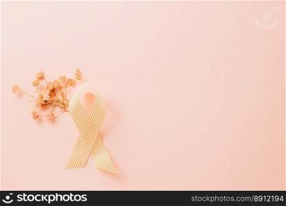 Pink awareness ribbon sign and paper card flower of World Cancer Day on pink background with copy space, concept of medical and health care support, Breast cancer awareness concept, 4 February