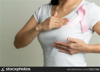 pink badge ribbon on woman chest to support breast cancer cause. breast cancer awareness concept