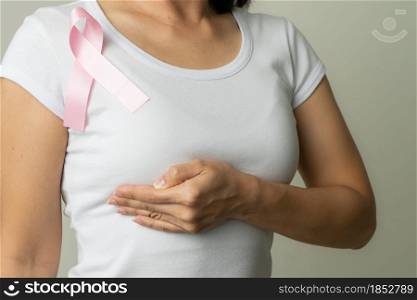 pink badge ribbon on woman chest to support breast cancer cause. breast cancer awareness concept