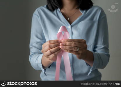 pink badge ribbon on woman hand to support breast cancer cause. breast cancer awareness concept