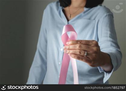 pink badge ribbon on woman hand to support breast cancer cause. breast cancer awareness concept
