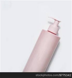 Pink beauty product bottle with pumps on white background, top view