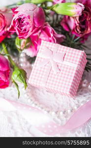 Pink box with little present and flowers. Pink box