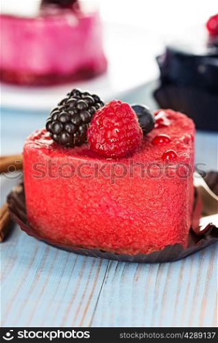 Pink cake with berries on wooden background