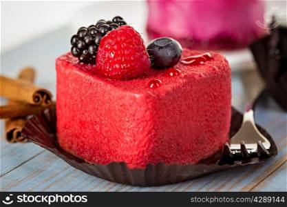 Pink cake with berries on wooden background