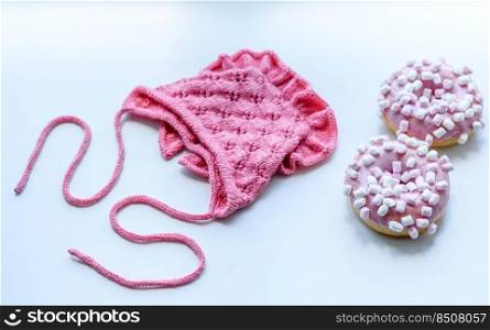 Pink cap for a young child. Clothing in the first days of the child’s life. Hat tied with your own hands. Pink cap for a young child. Clothing in the first days of the child’s life
