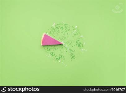 Pink chocolate mousse in pie crust slice on a green background. Just one piece of pie and grease traces. Last piece of pie. Christmas pink dessert.