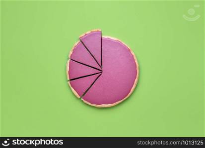 Pink chocolate mousse in pie crust, with four slices cut, on a green background. Flat lay of Ruby chocolate pie cut in pieces. Christmas pink dessert