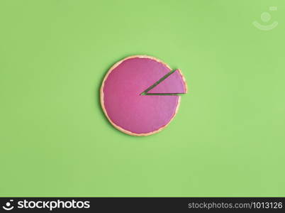 Pink chocolate pie and one slice cut and separated on a green background. Flat lay of a chocolate tart and just one piece cut. Christmas pink dessert
