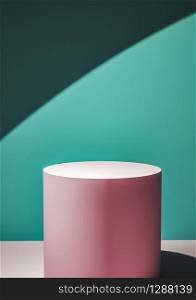 Pink circular display plinth against a green wall in a shaft of sunlight creating a mix of perspectives and shadows for a design template or product placement