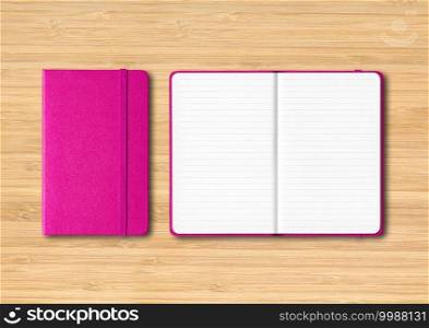Pink closed and open lined notebooks mockup isolated on wooden background. Pink closed and open lined notebooks on wooden background