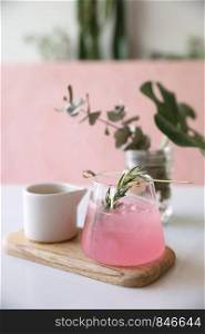 Pink cocktail with rosemary and lychee in pink background