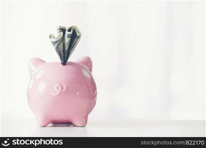 pink color piggy bank on white table, saving concept