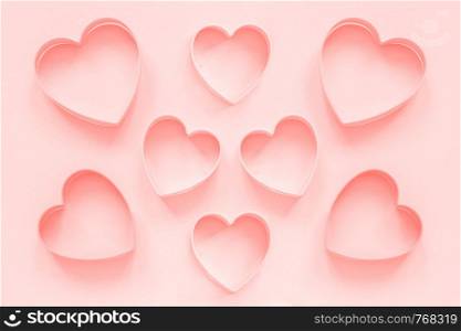 Pink cutters cookies in heart shape on pastel pink background, colar toned. Love romantic pattern, template.. Pink cutters cookies in heart shape on pastel pink background, colar toned. Love romantic pattern, template