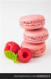 Pink dessert cake macaron or macaroon with raspberry and mint leaf on stone kitchen table background .
