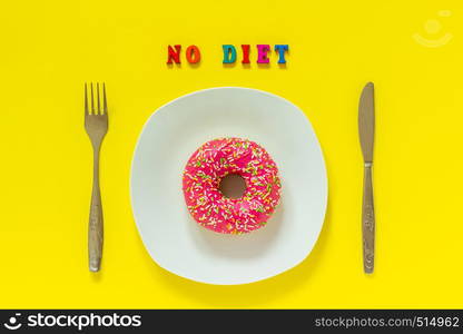 Pink donut on white plate and cutlery table knife fork Text NO DIET. Still life on yellow background. Top view Flat lay Concept No Diet day. No diet and Pink donut on white plate and knife fork on yellow background.