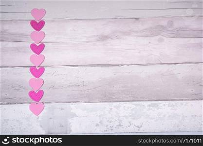 Pink felt hearts on a background of old wooden planks resembling an old parquet floor. Concept of valentines day and love in general.. Pink felt hearts on a background of old wooden planks resembling an old parquet floor. Concept of valentines day and love in general