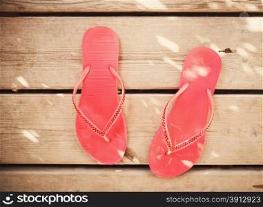 Pink flip flop sandals on wood background