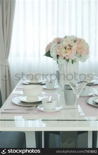 Pink flower at the center of romantic dining table in dining room