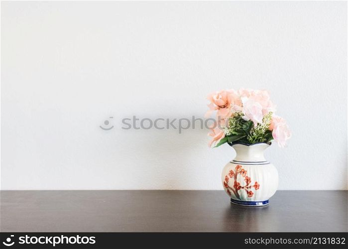 pink flower in jar on wood table with space for text
