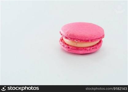 Pink French macaroon isolated on white background. Tasty colourful macaroons. Cookie made of two smooth halves, fastened with stringy fillings. French pastry made from egg whites.