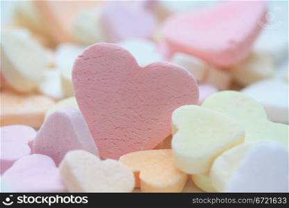 pink fruit candy heart on a pile of candy hearts