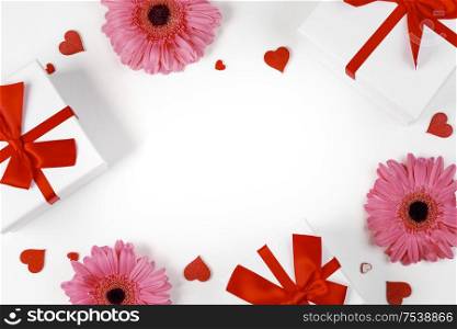 Pink gerbera flowers gifts and red hearts composition on white background top view with copy space. Valentine&rsquo;s day, birthday, wedding, Mother&rsquo;s day concept. Copy space. Pink gerbera hearts card