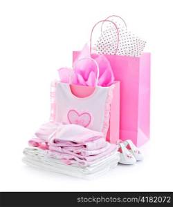 Pink gift bags and infant clothes for girl baby shower isolated on white