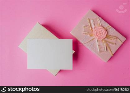 pink gift box and blank card on pink background