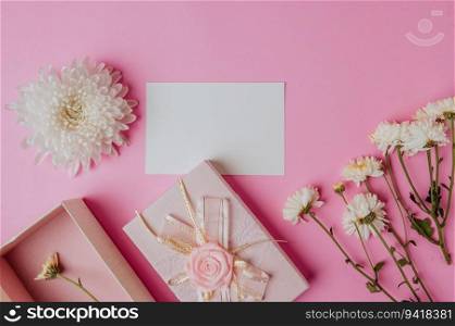 pink gift box, flower and blank card on pink background