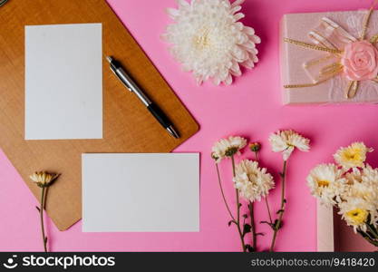 pink gift box, flower, pen, wood board and blank card on pink background