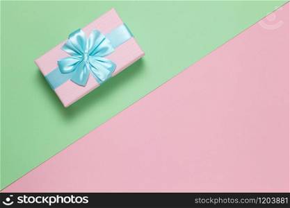 Pink gift box with blue bow on pastel two-color background pink and green, copy space, flat lay. March 8, February 14, birthday, St. Valentine?s, Mother?s, Women?s day celebration concept. Horizontal.