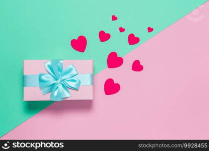 Pink gift box with blue bow on pastel two-color background pink and mint, copy space, flat lay. March 8, February 14, birthday, St. Valentine"s, Mother"s, Women"s day celebration concept. Horizontal.