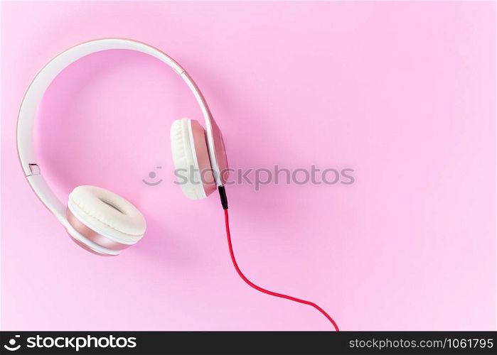 Pink headphone and red cable on pastel color pink background. Music concept. Blank copy space