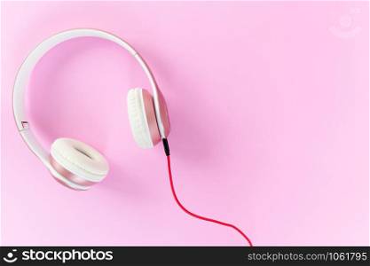 Pink headphone and red cable on pastel color pink background. Music concept. Blank copy space