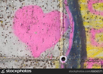 Pink heart graffiti over grunge cement wall