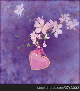 pink heart hanging on the blooming tree brunch on grunge dark blue background