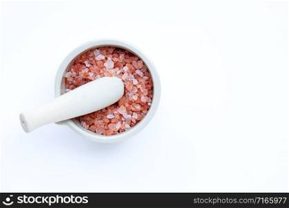 Pink himalayan salt in mortar with pestle on with background. Copy space
