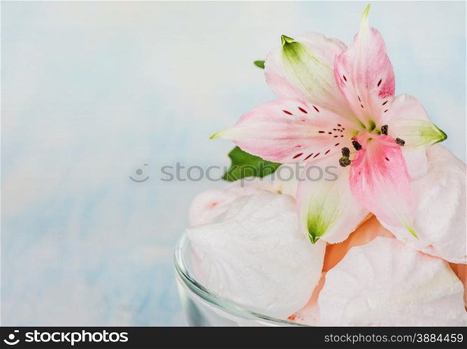 Pink meringue and a flower in a glass bowl close-up
