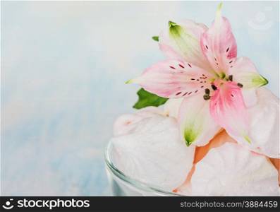 Pink meringue and a flower in a glass bowl close-up
