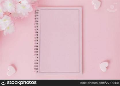 Pink notebook with flower on a pink background