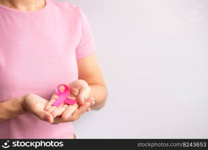 Pink October Breast Cancer Awareness month, woman hand hold pink Ribbon and wear shirt for support people life and illness. National cancer survivors month, Mother and World cancer day concept