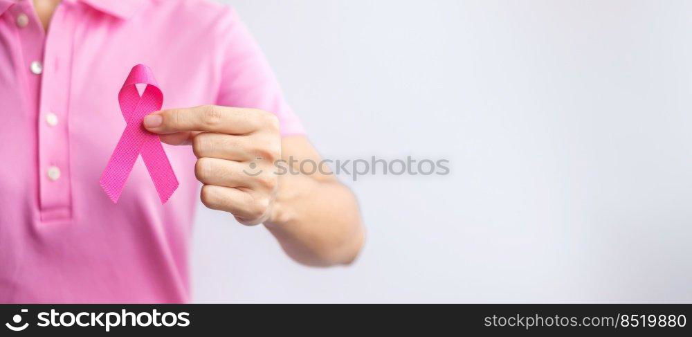 Pink October Breast Cancer Awareness month, woman hand hold pink Ribbon and wear shirt for support people life and illness. National cancer survivors month, Mother and World cancer day concept