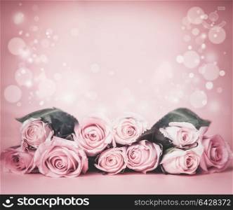 Pink pale floral background with roses bunch on table with bokeh. Holidays greeting layout or wedding concept