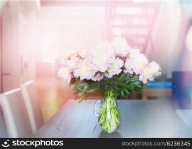 Pink pale peonies bunch on dining table in apartment. Home Interior. Home Flowers decoration