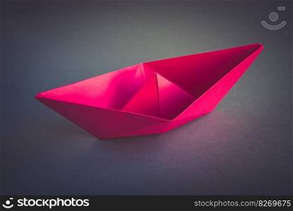 Pink paper boat origami isolated on a blank grey background.. Pink paper boat origami isolated on a grey background