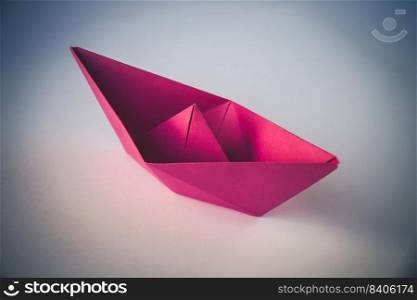 Pink paper boat origami isolated on a blank white background.. Pink paper boat origami isolated on a white background